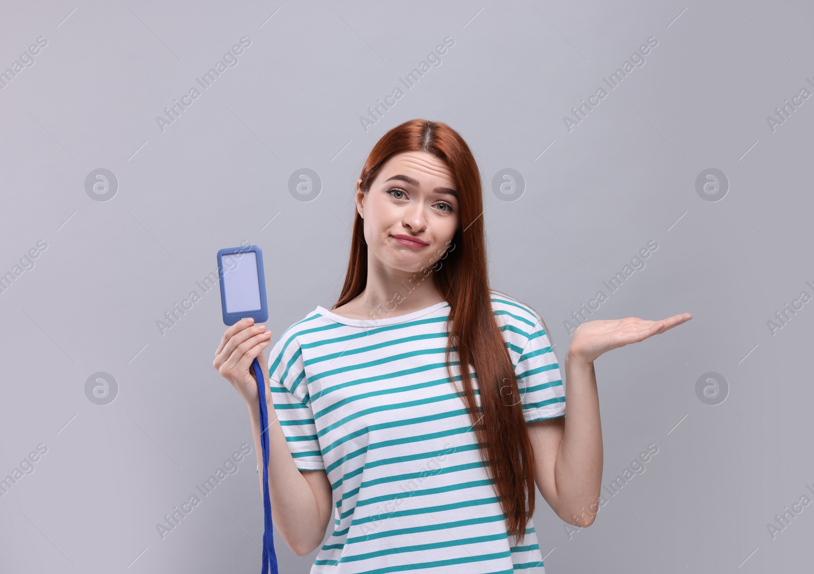 Photo of Disappointed woman with vip pass badge on light grey background