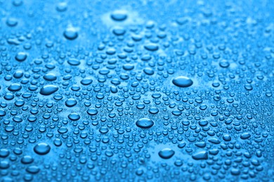Photo of Many water drops on dark dusty blue background, closeup
