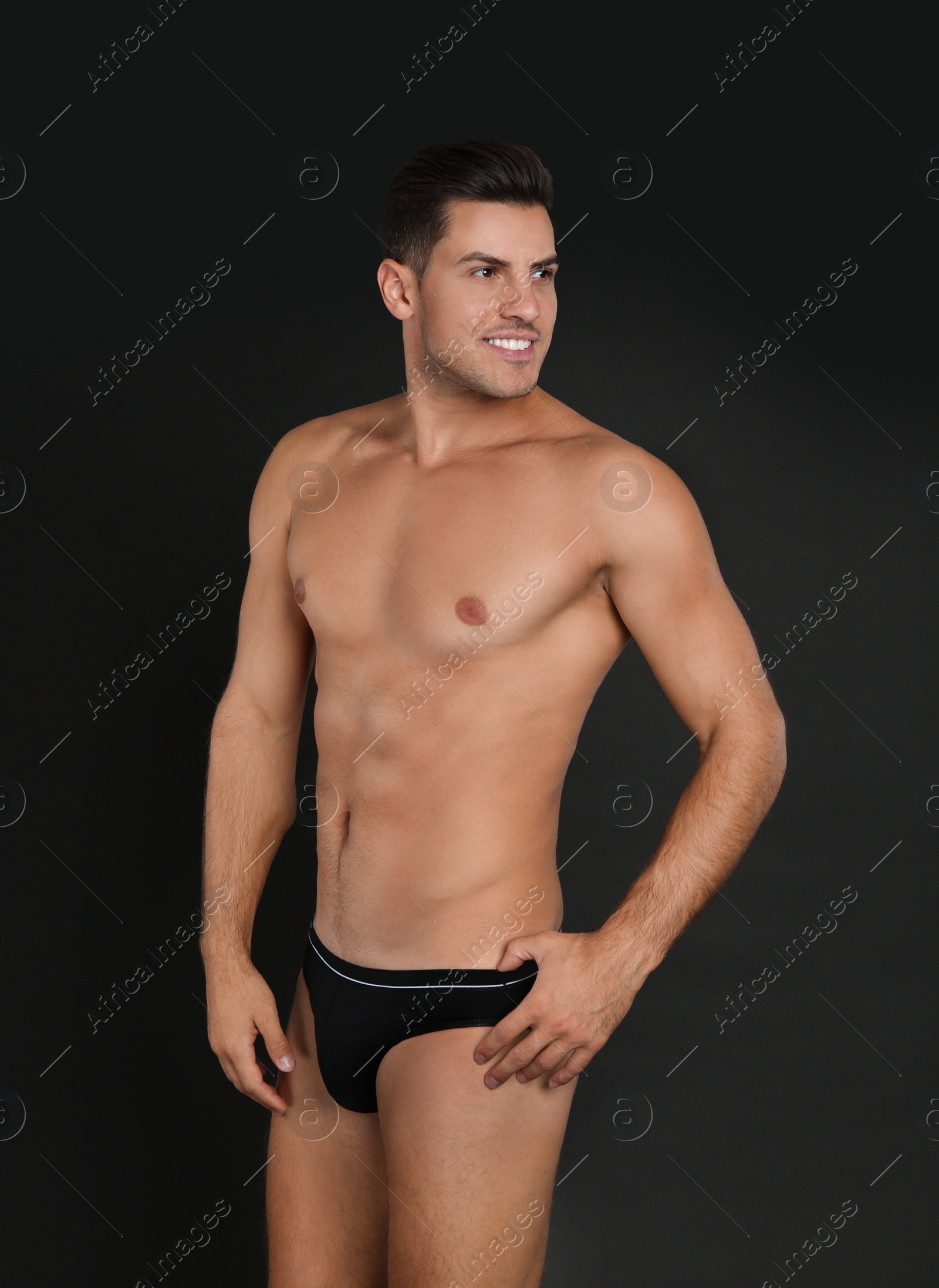 Photo of Handsome man in underwear on black background