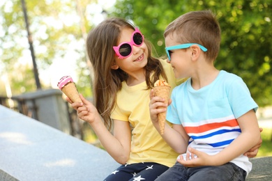 Photo of Cute little children with delicious ice creams in park