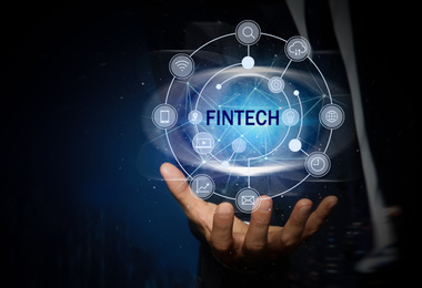 Image of Fintech concept. Man demonstrating different icons on dark blue background, closeup
