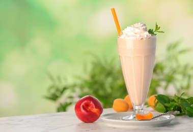 Photo of Glass with delicious milk shake on table