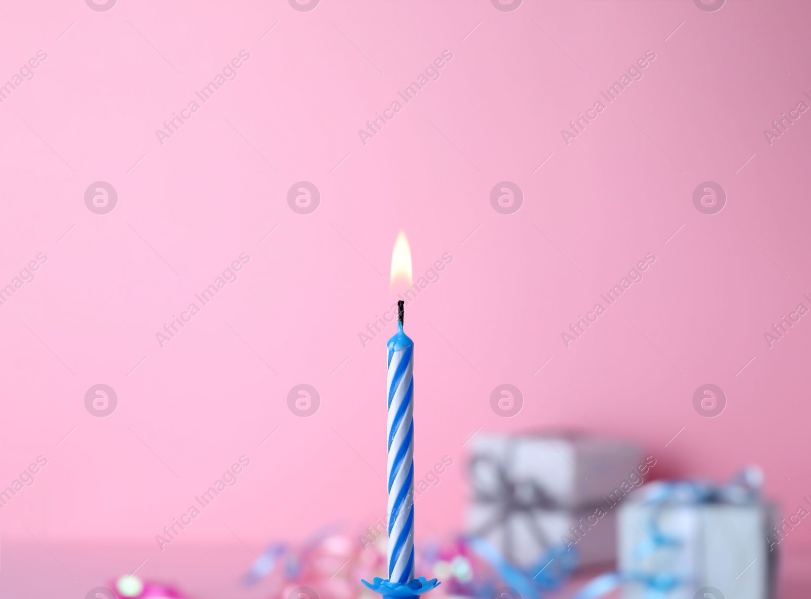 Photo of Burning birthday cake candle on color background. Space for text