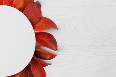 Photo of Flat lay composition with blank card and autumn leaves on white wooden table. Space for text
