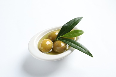 Photo of Bowl with fresh olives in oil on white background