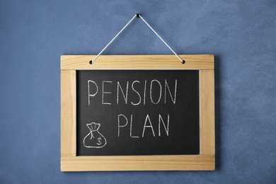Photo of Chalkboard with phrase Pension Plan hanging on blue wall