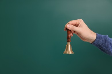 Photo of Teacher with school bell near chalkboard, closeup. Space for text