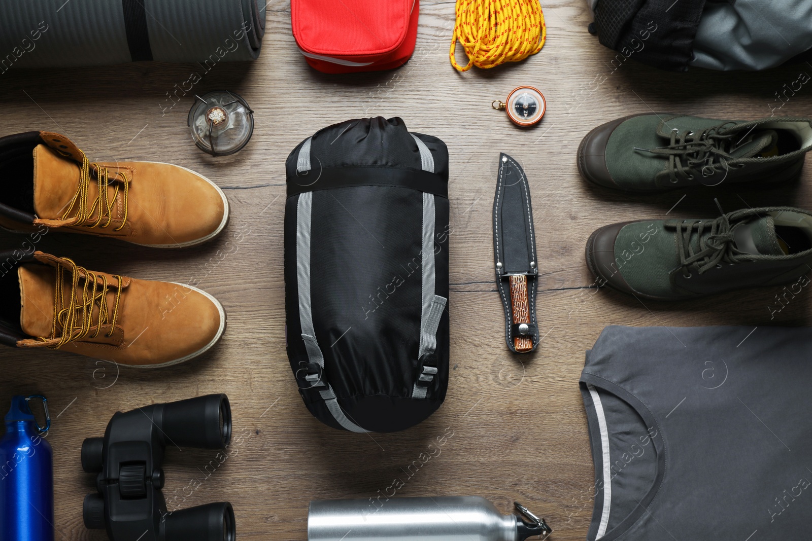 Flat lay composition with different camping equipment on wooden background Photo of Flat lay composition with different camping equipment on wooden background