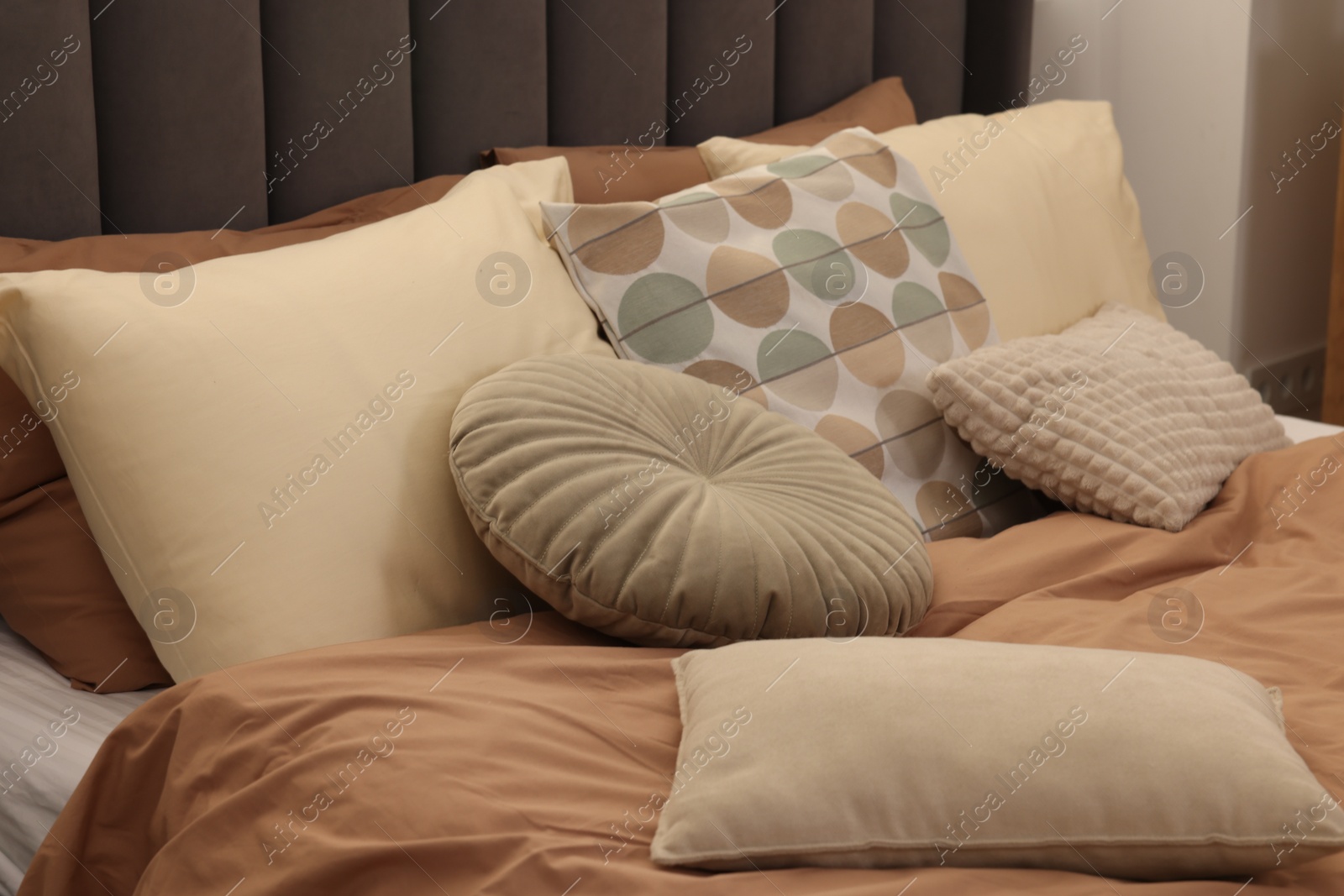 Photo of Large comfortable bed with soft pillows indoors. Home textile