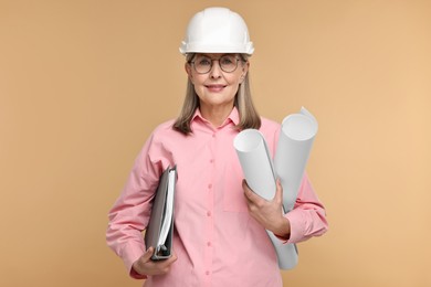 Photo of Architect in hard hat with drafts and folder on beige background