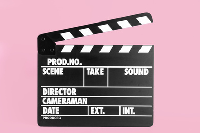 Photo of Clapper board on pink background. Cinema production