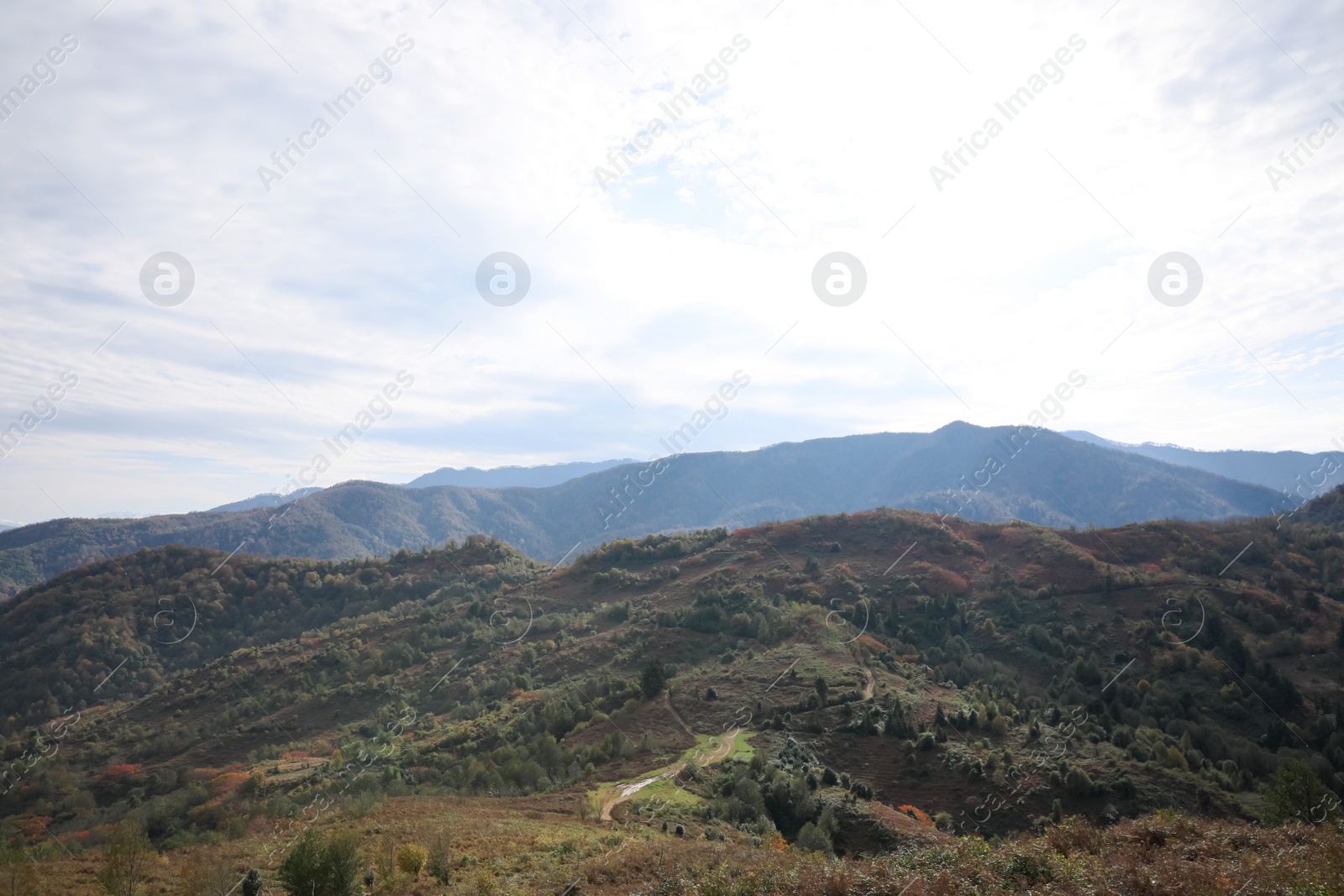 Photo of Picturesque view of green hills and mountains under cloudy sky