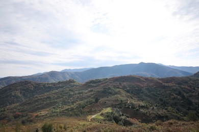 Photo of Picturesque view of green hills and mountains under cloudy sky