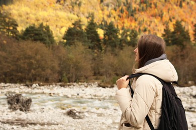Woman with backpack in beautiful mountains. Space for text