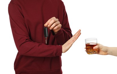 Photo of Man with car keys refusing alcohol on white background, closeup. Don't drink and drive concept