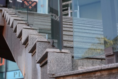 Photo of Beautiful grey stairs with tempered glass outdoors