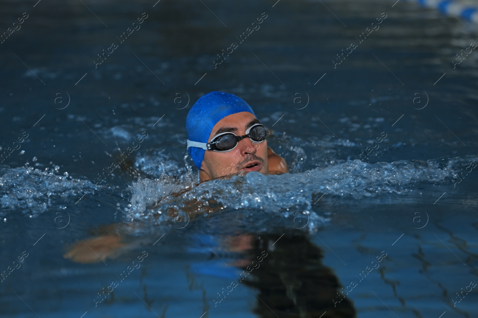 Photo of Young athletic man swimming in pool indoors