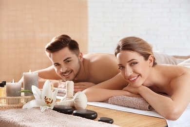 Young couple with spa essentials in wellness center