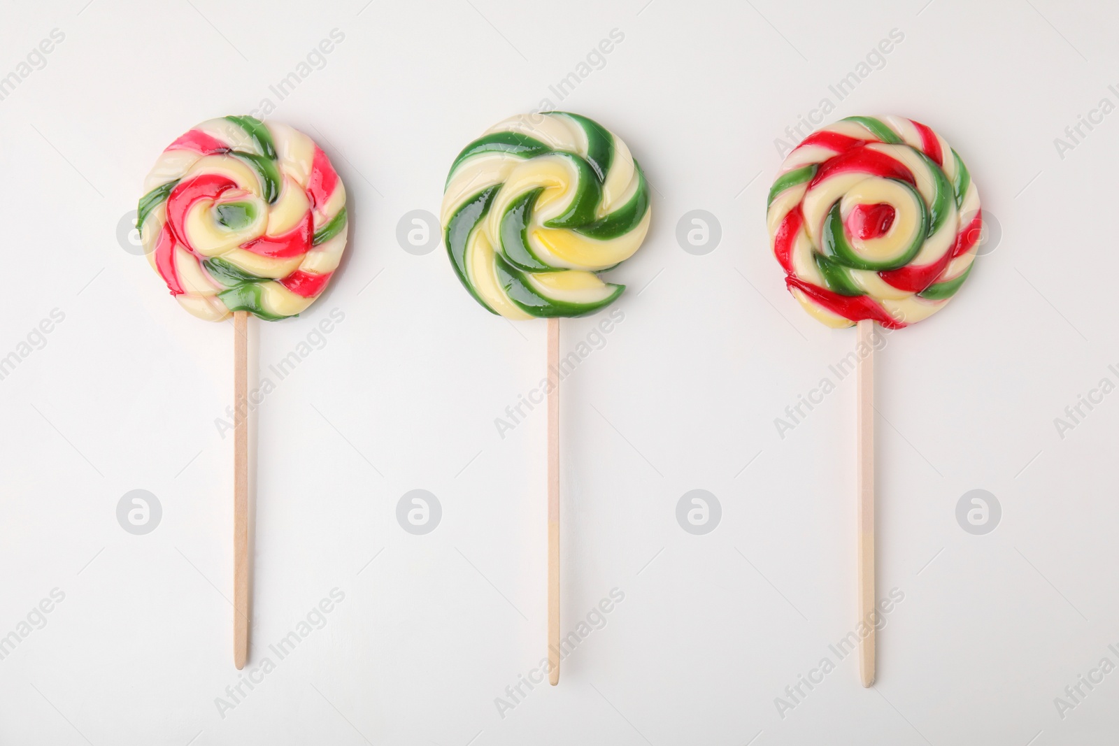 Photo of Colorful lollipops on white background, flat lay