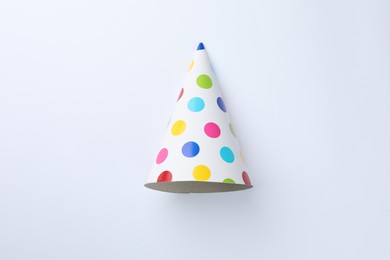 Photo of One beautiful party hat on light background, top view