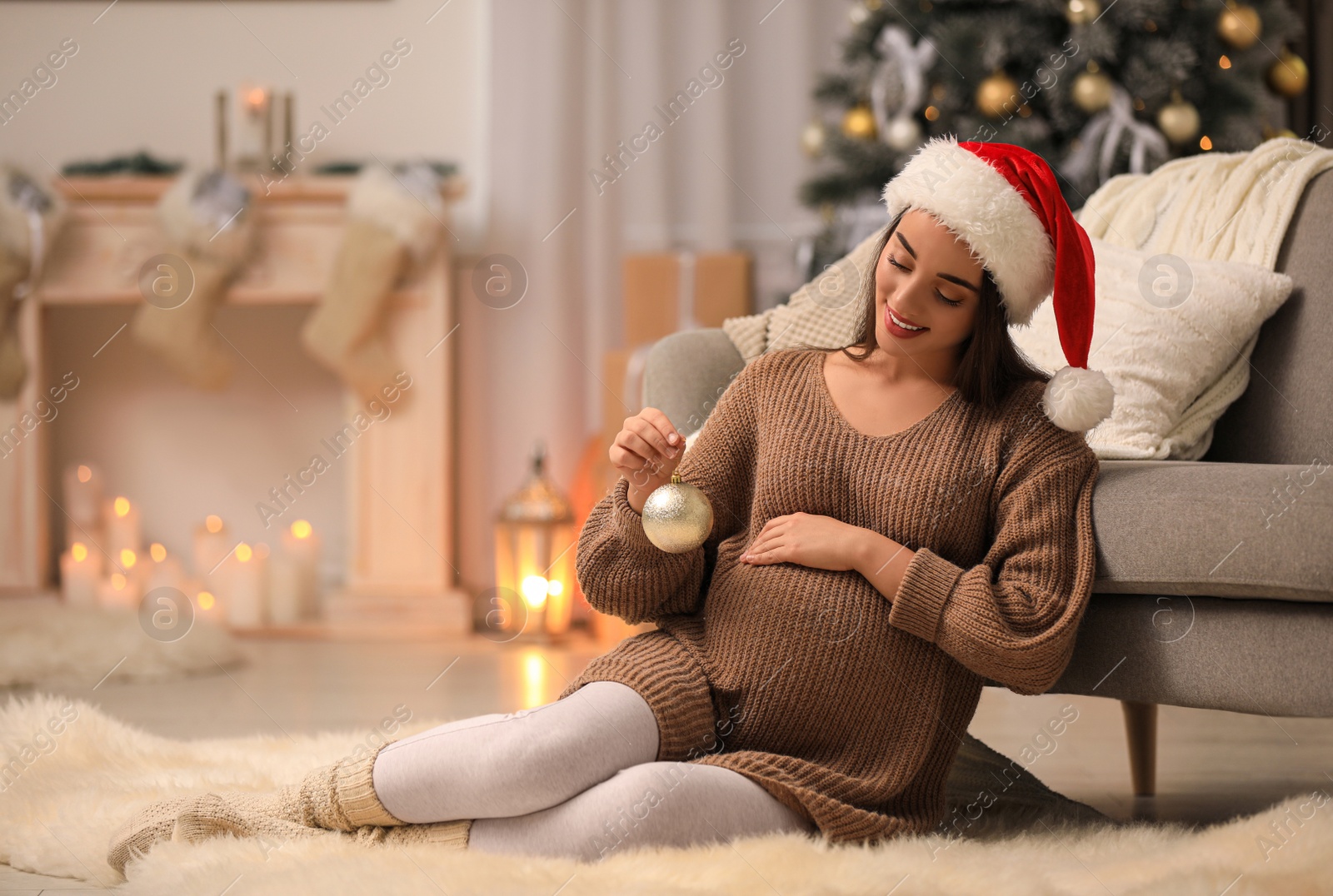 Photo of Happy pregnant woman with Christmas ball at home. Expecting baby