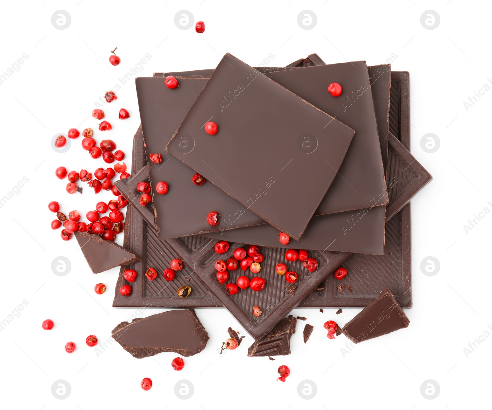 Photo of Red peppercorns and pieces of dark chocolate isolated on white, above view
