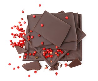 Red peppercorns and pieces of dark chocolate isolated on white, above view