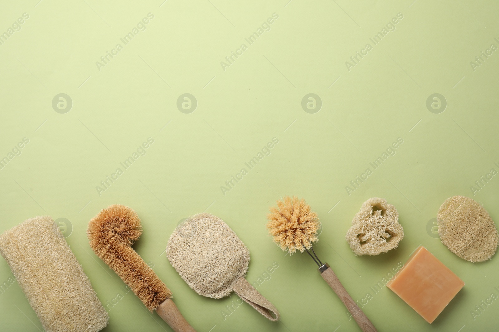 Photo of Flat lay composition with eco friendly products on green background, space for text