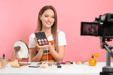 Beauty blogger filming make up tutorial on pink background