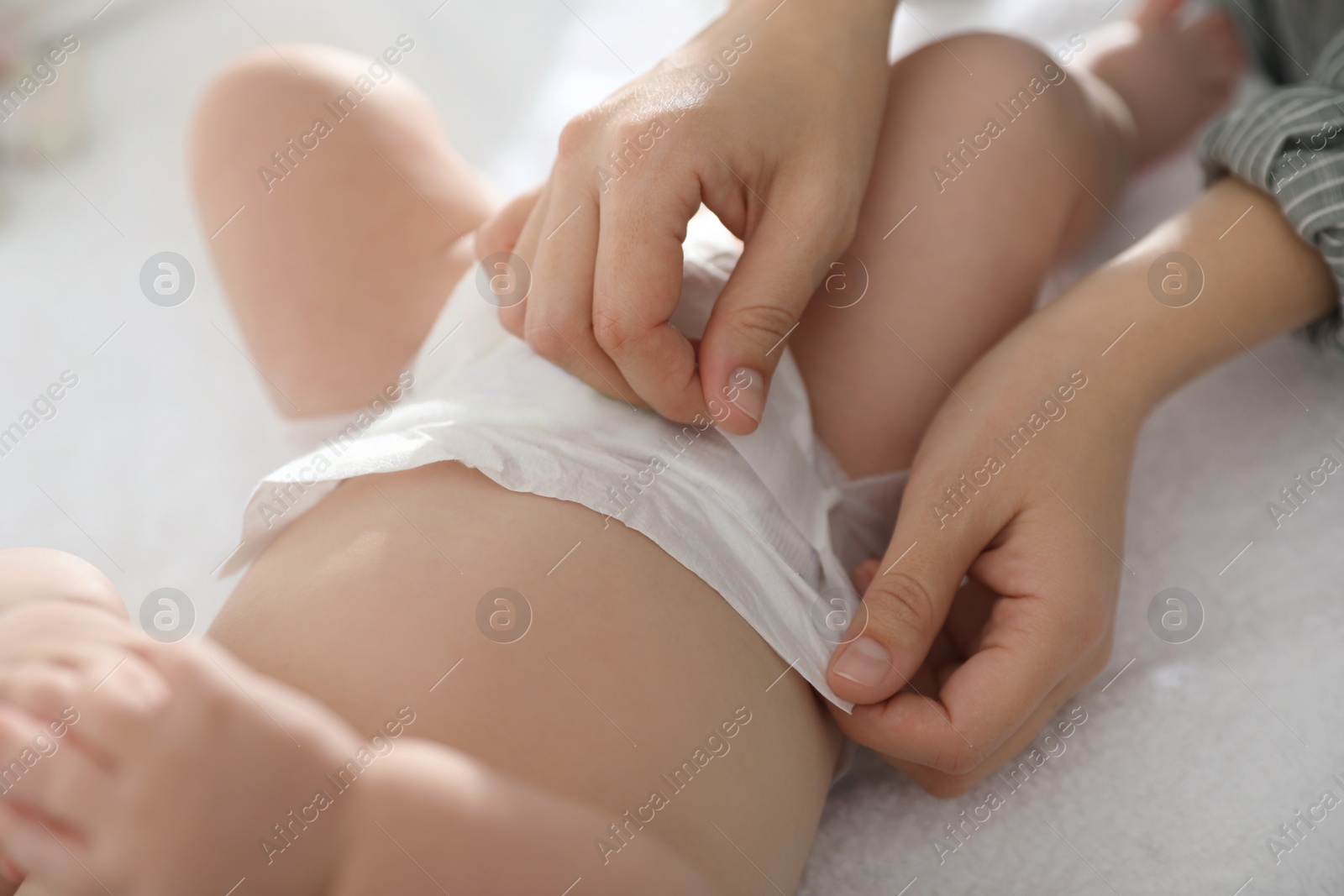 Photo of Mother changing her baby's diaper on table, closeup