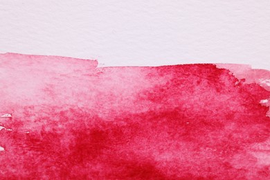 Photo of Abstract pink watercolor painting on white paper, top view