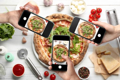 Image of People taking pictures of tasty pizza on white wooden table, top view
