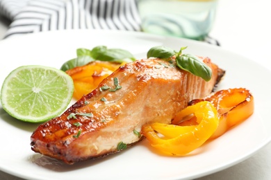 Tasty cooked salmon with vegetables on plate, closeup