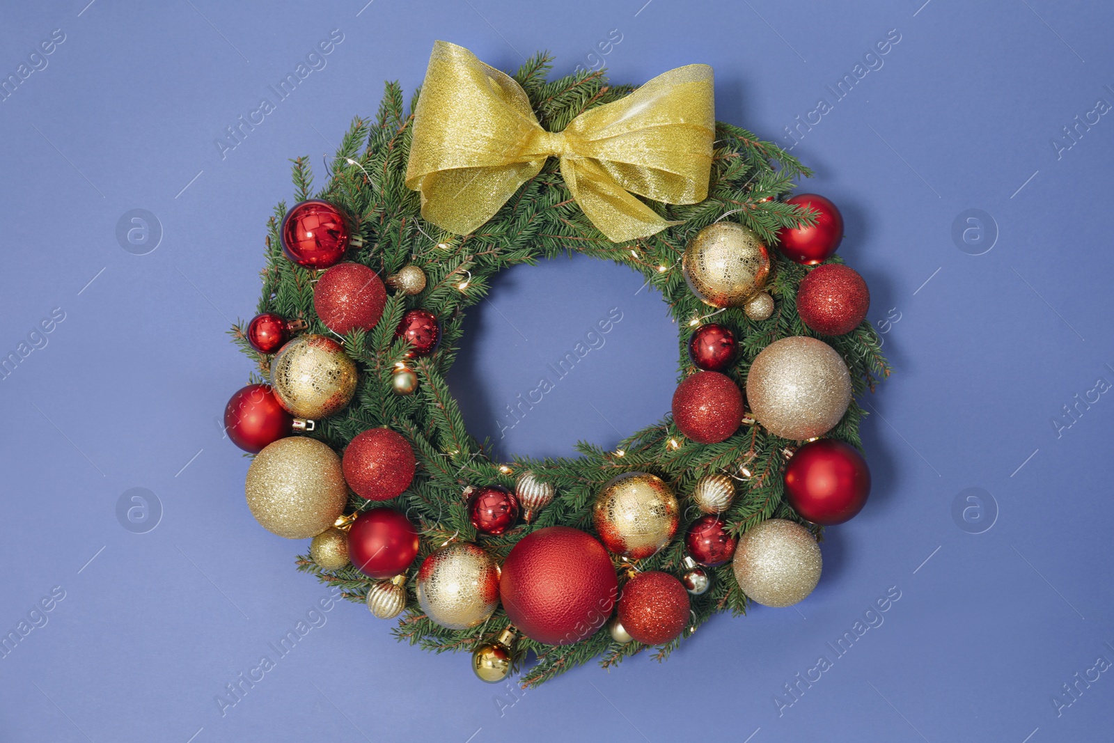 Photo of Beautiful Christmas wreath with festive decor on blue background