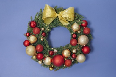 Beautiful Christmas wreath with festive decor on blue background