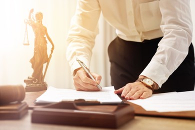 Image of Lawyer working with document at table in office, closeup