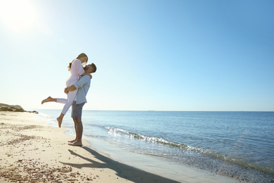Happy young couple on beach near sea. Honeymoon trip