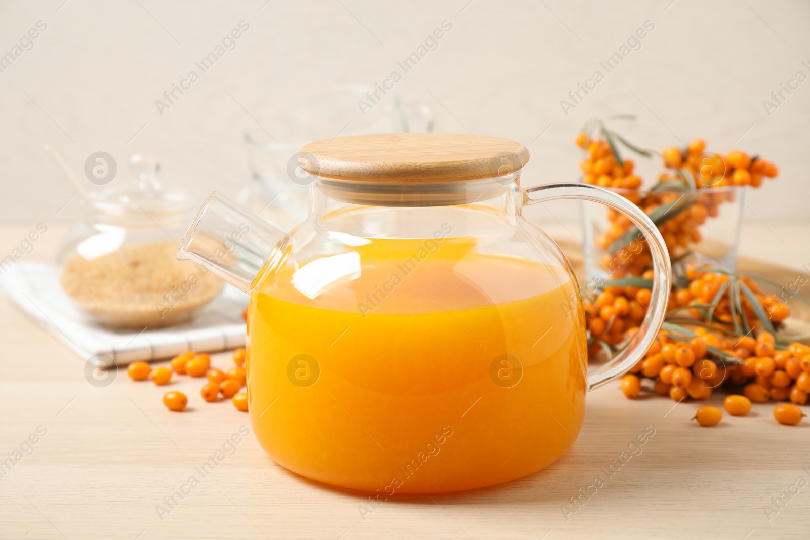 Photo of Delicious sea buckthorn tea on wooden table