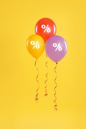 Image of Discount offer. Balloons with percent sign on golden background