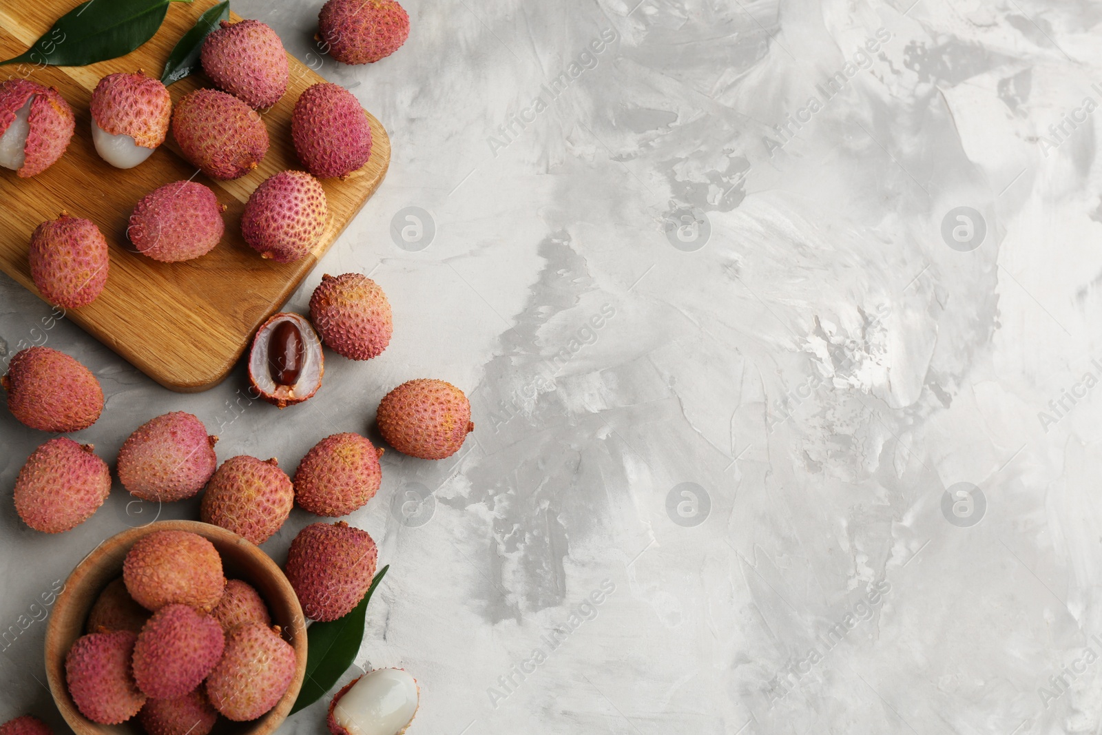 Photo of Fresh ripe lychee fruits on light grey table, flat lay. Space for text