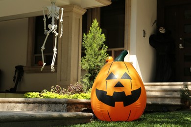 Photo of Inflatable Jack O'Lantern near house decorated for Halloween