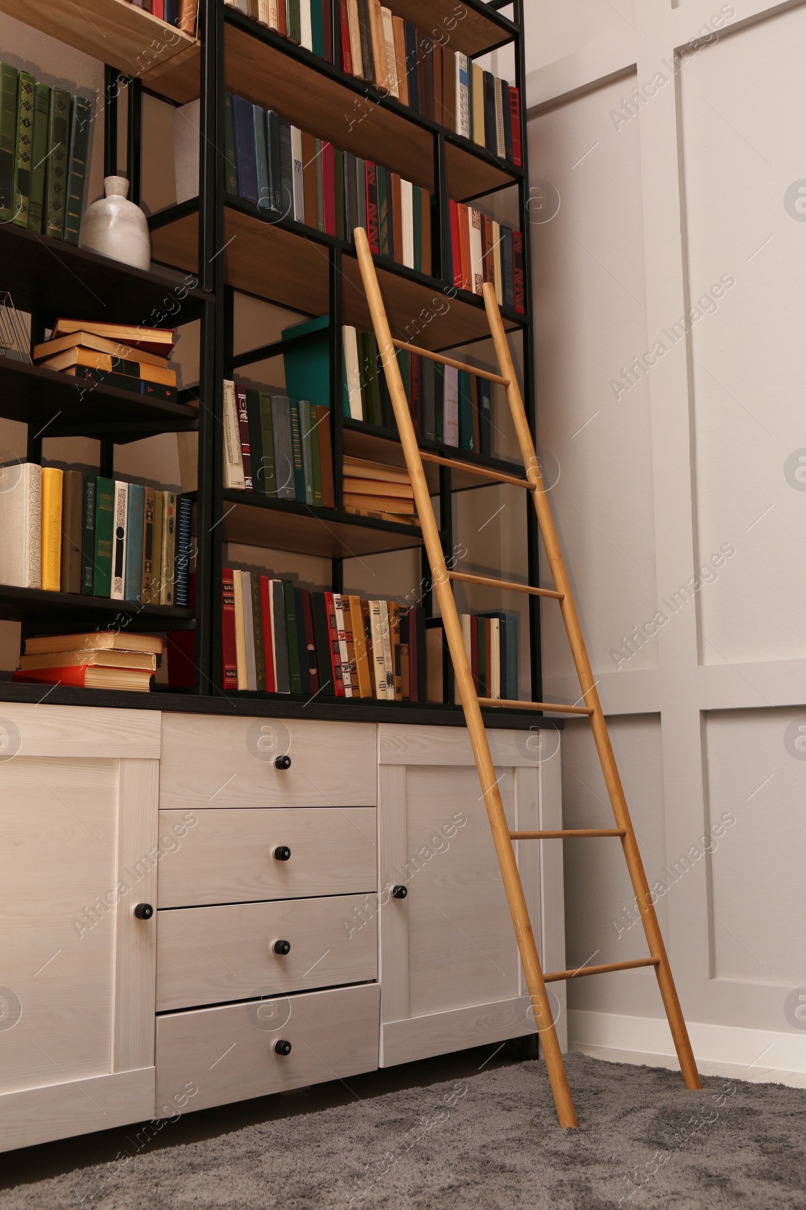 Photo of Home library interior with wooden ladder and collection of books on shelves