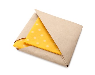 Photo of Packed yellow reusable beeswax food wraps on white background