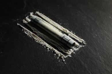 Drug addiction. Cocaine and rolled dollar banknote on dark textured background, closeup