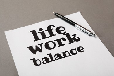 Photo of Paper sheet with text Life, Work balance and pen on grey table