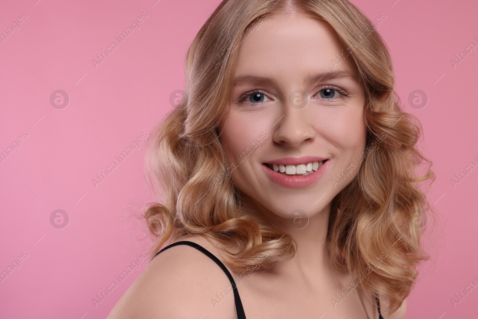 Photo of Portrait of beautiful woman with blonde hair on pink background. Space for text