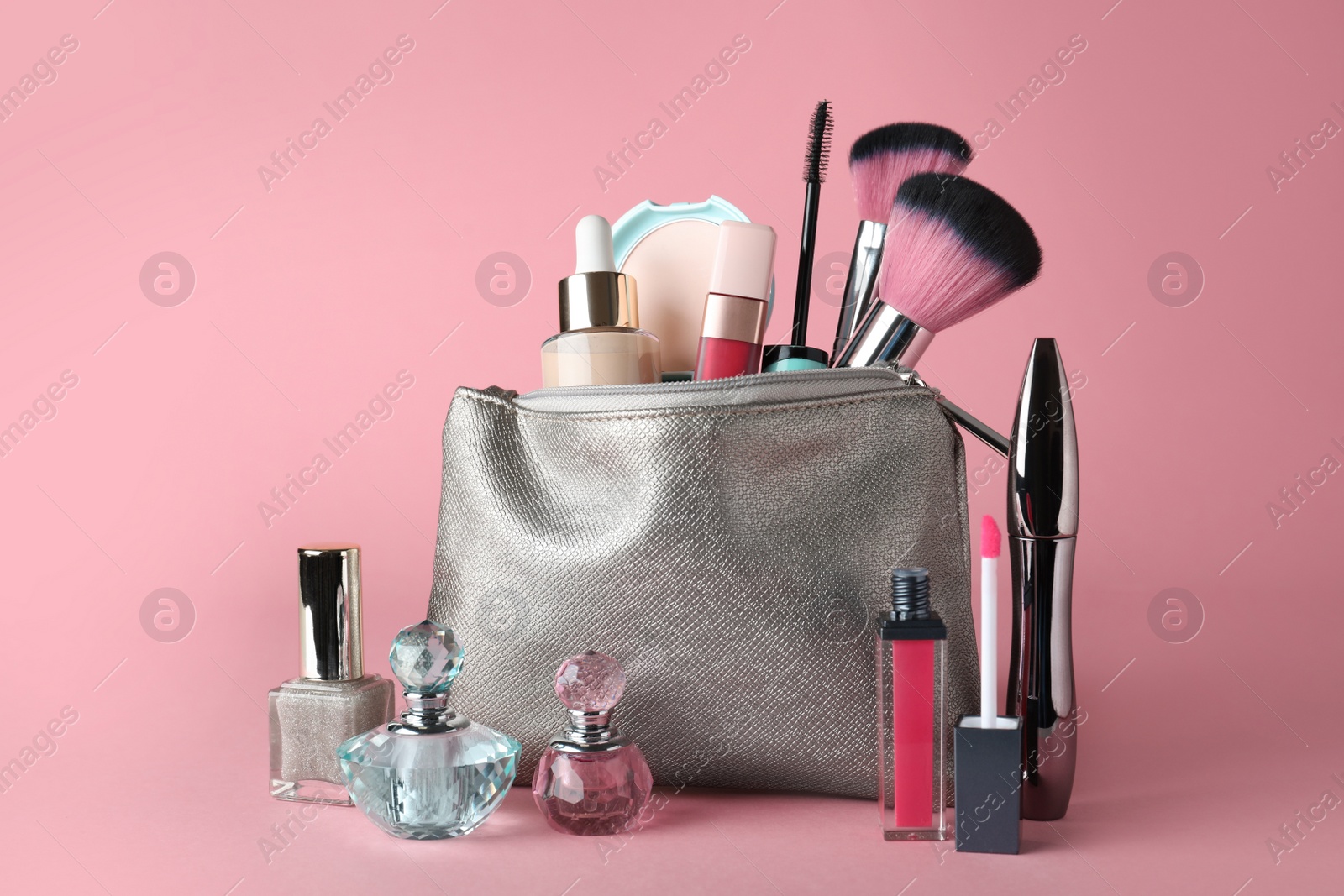Photo of Cosmetic bag and makeup products with accessories on pink background