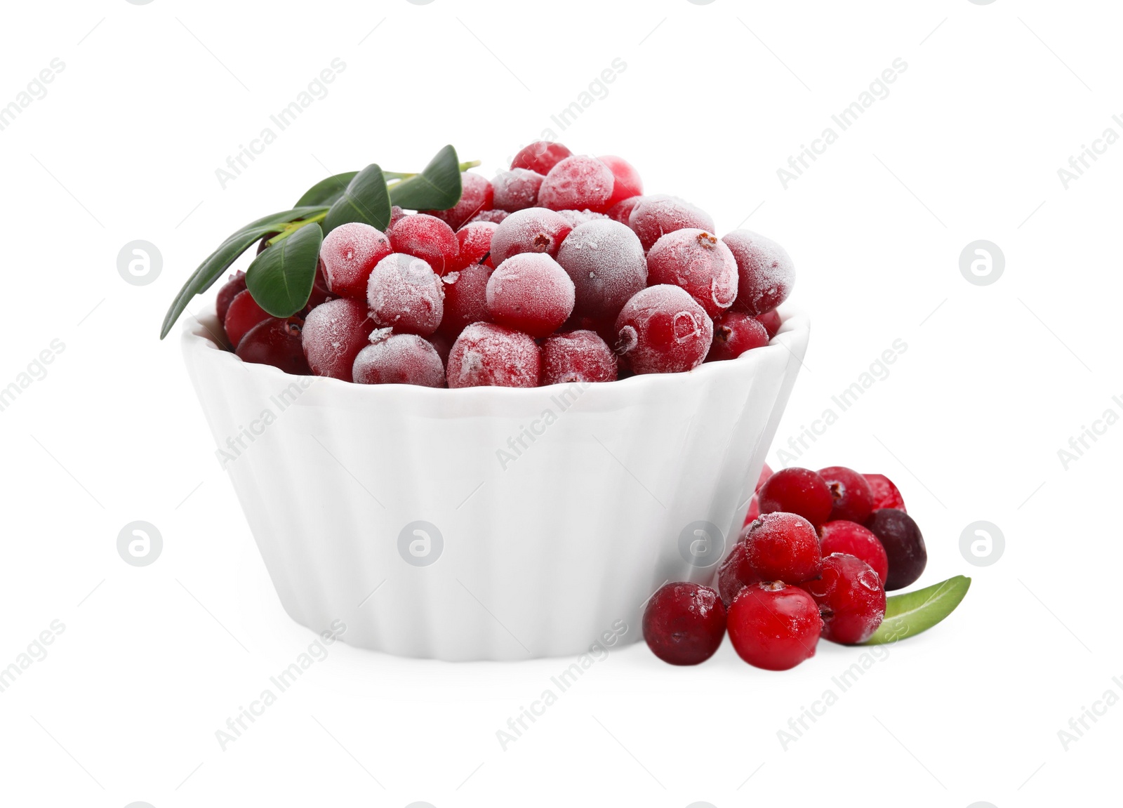 Photo of Frozen red cranberries in bowl and green leaves isolated on white