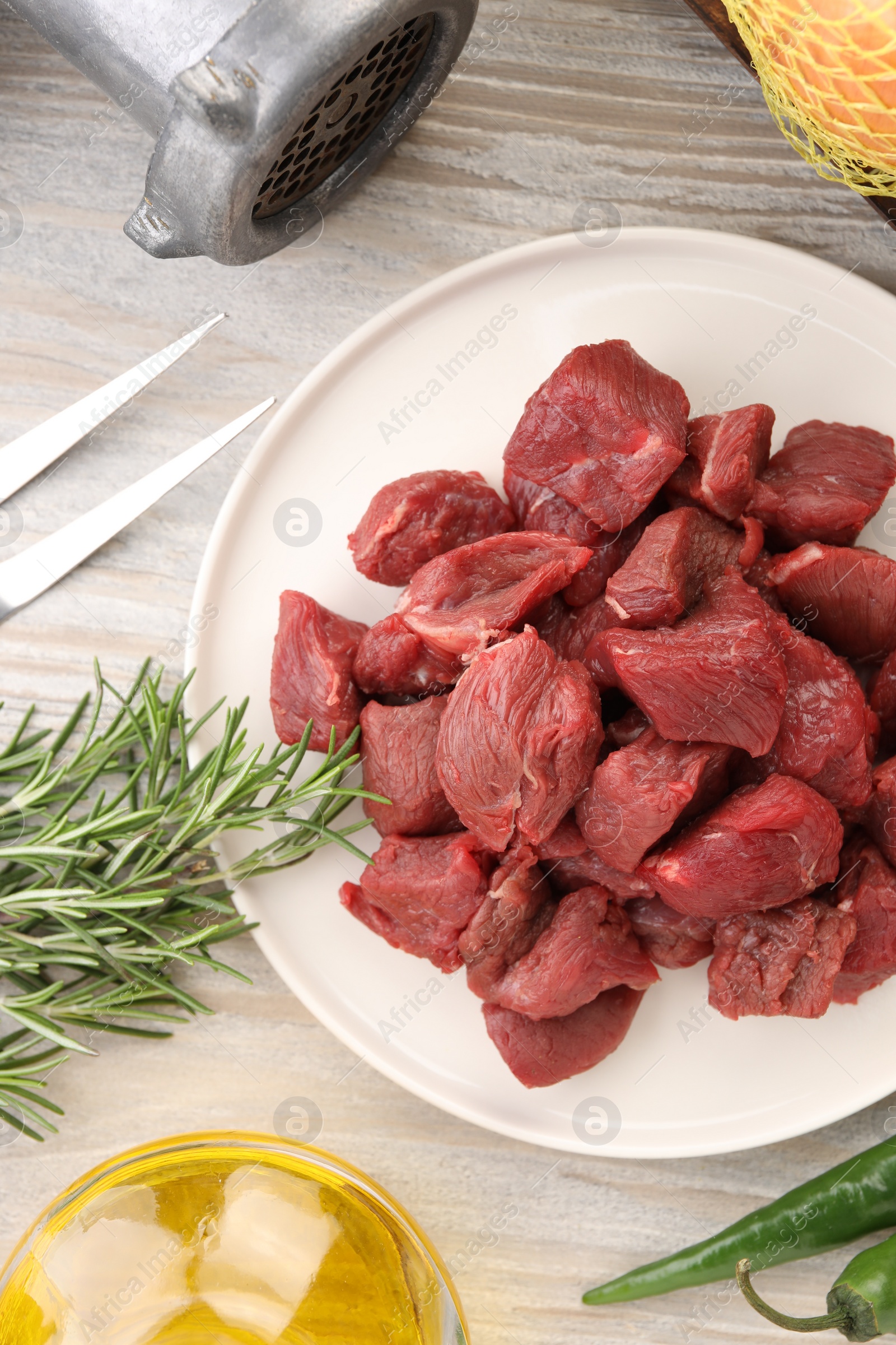 Photo of Pieces of beef and products on white wooden table, flat lay