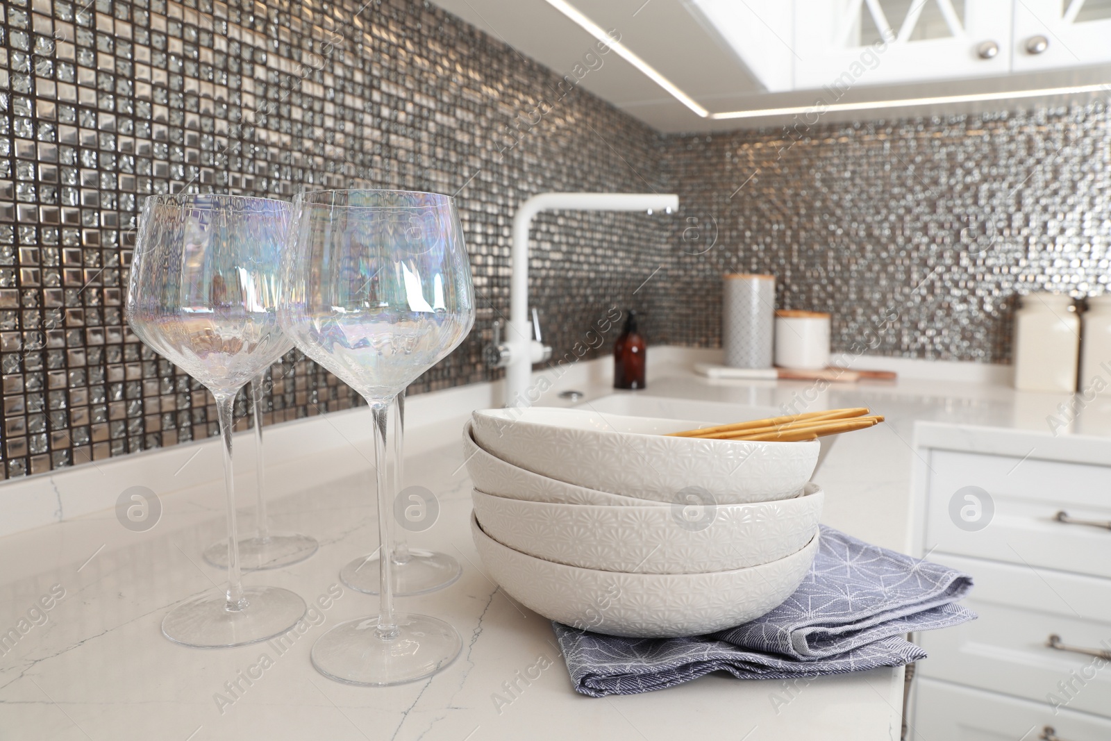 Photo of Beautiful ceramic dishware and glasses on countertop in modern kitchen